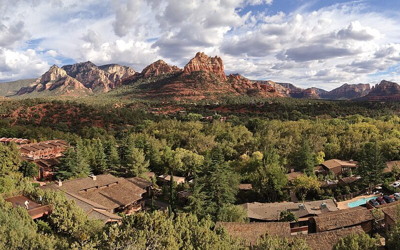 Sedona red rock formations with town and green trees in the foreground, Arizona