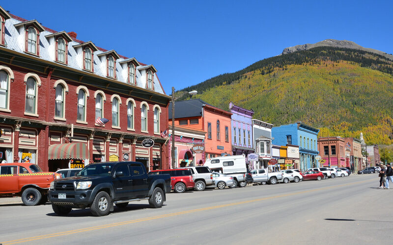 Colorful historic buildings along the main street of Silverton Colorado with San Juan Mountains in the background