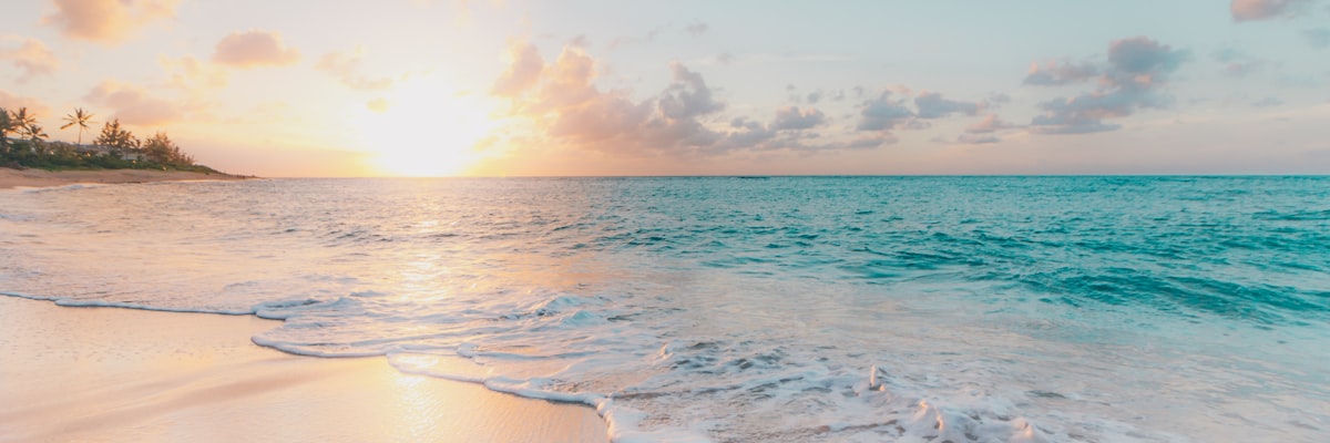 Florida Gulf Coast beach with turquoise waters and white sand stretching along the coastline