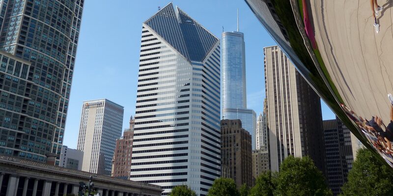 Chicago skyline reflected near Cloud Gate sculpture in Millennium Park