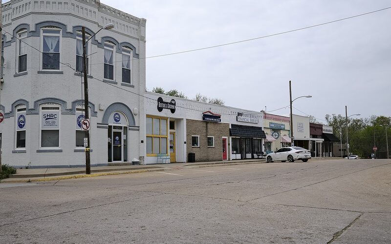 Quiet tree-lined residential street in Spring Hill Kansas with craftsman-style homes and wide sidewalks in a small-town setting