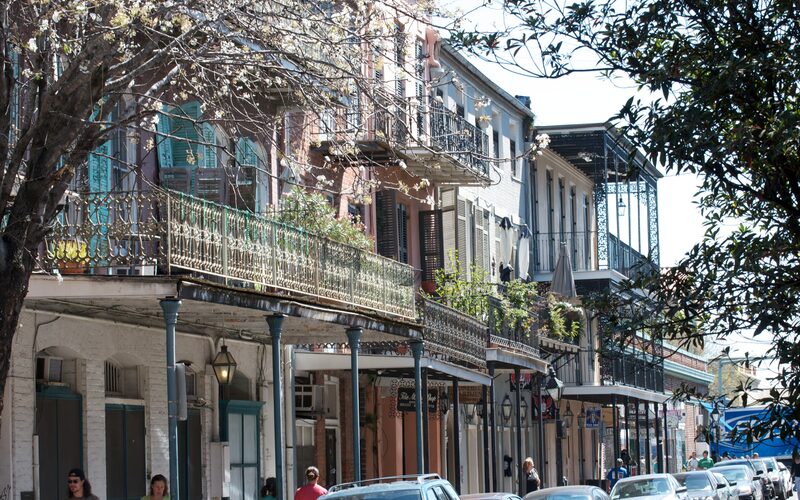 French Quarter buildings with ornate wrought iron balconies on Dumaine Street in New Orleans