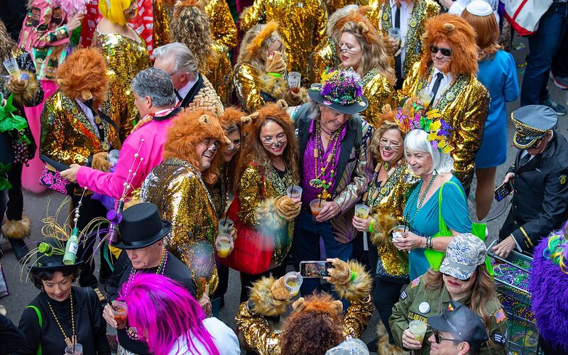 Costumed Mardi Gras revelers in elaborate gold and sequined outfits in New Orleans