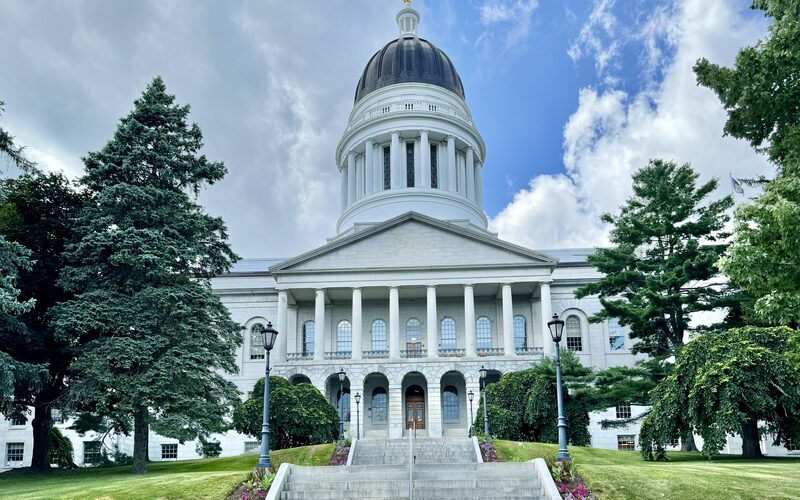 Maine State House in Augusta, a Classical Revival building with white granite facade, columned portico, and distinctive dome