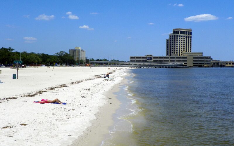 White sand beach along the Mississippi Gulf Coast in Biloxi with blue sky and waterfront
