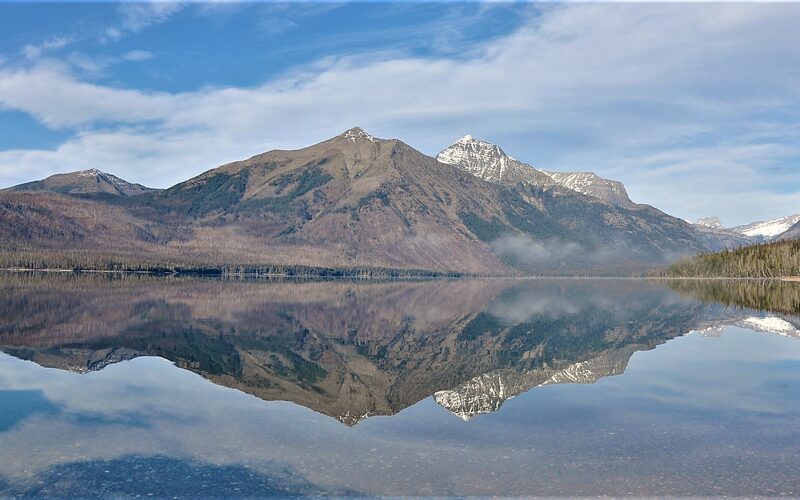 Lake McDonald in Glacier National Park, Montana, with snow-capped Rocky Mountains reflected in calm water
