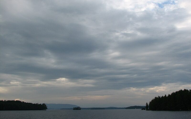 Lake Winnipesaukee with islands and mountains under overcast skies in New Hampshire