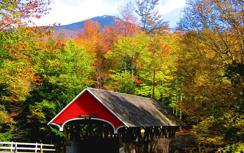 Flume Covered Bridge near Albany in New Hampshire's White Mountains surrounded by vibrant autumn foliage