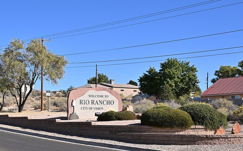 Welcome to Rio Rancho sign with suburban homes in New Mexico