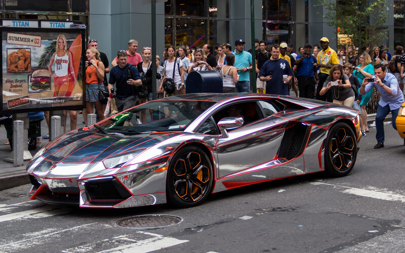 Times Square at night with bright neon signs, Broadway marquees, and crowds of visitors in Midtown Manhattan