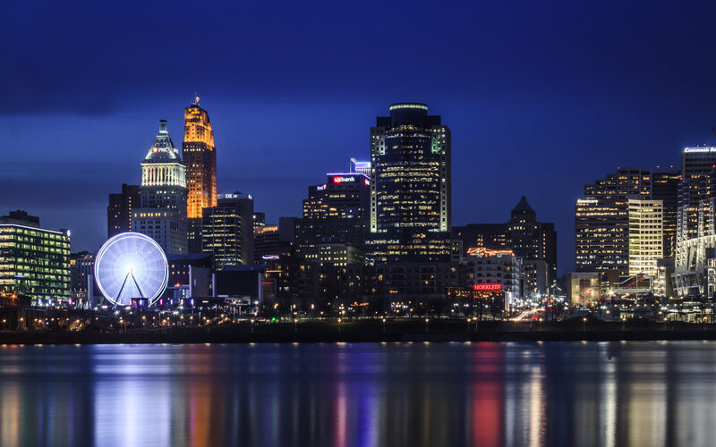 Cincinnati skyline at night across the Ohio River with SkyStar wheel