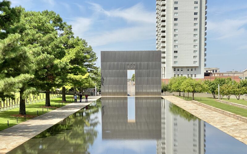 Oklahoma City National Memorial reflecting pool with the 9:03 gate and field of empty chairs on the lawn