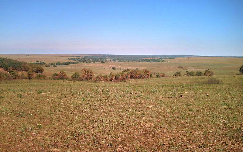 Oklahoma prairie landscape with rolling hills and dramatic sunset sky