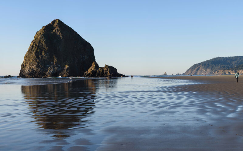 Cannon Beach Oregon with Haystack Rock rising from the Pacific Ocean shoreline at sunset