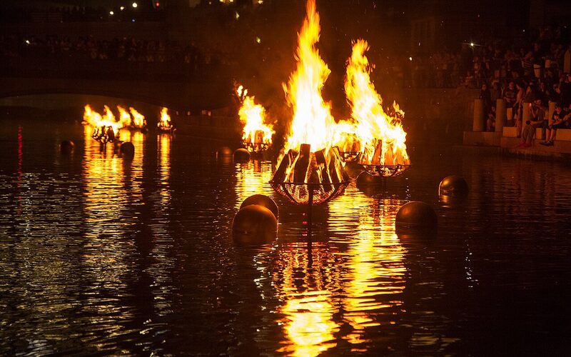 WaterFire art installation in Providence, Rhode Island with bonfires blazing on the river at night