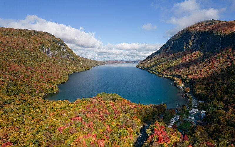 Aerial view of Lake Willoughby flanked by Green Mountains covered in vibrant fall foliage in Vermont
